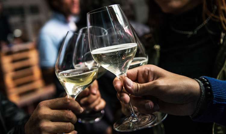 Imatge de recurs de tres persones brindant amb la seva copa de vi blanc