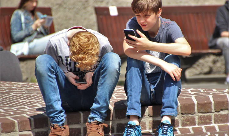 Imatge de dos adolescents amb el mòbil