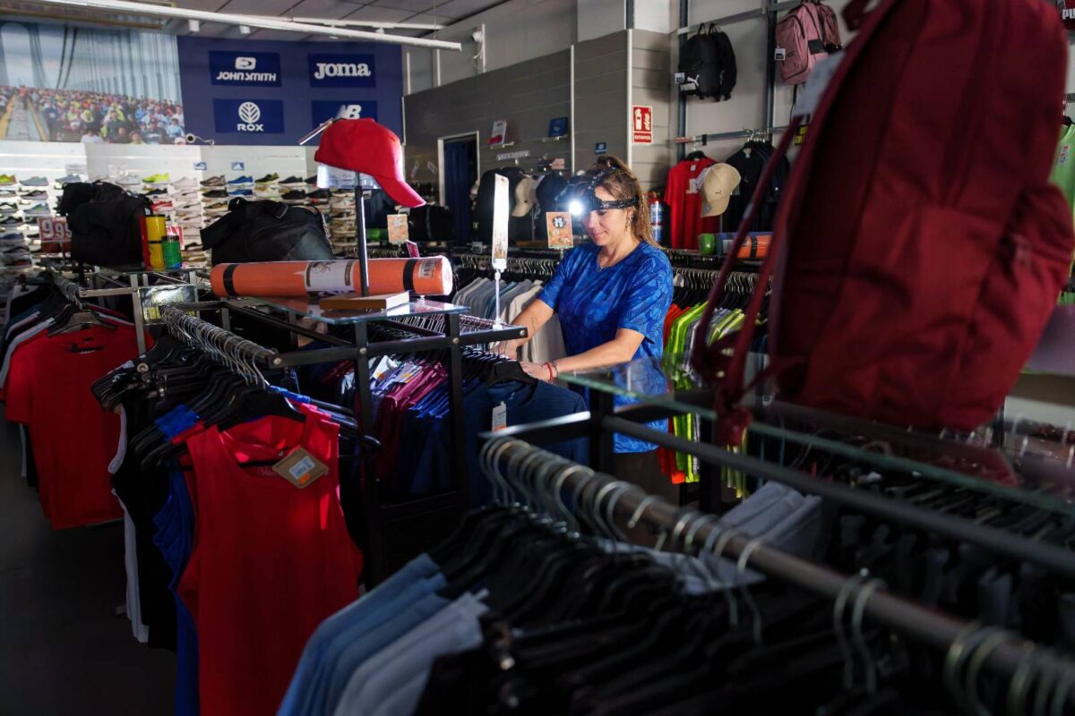 Una dependienta de una tienda de deporte trabaja con una linterna en la cabeza en Burgos el 28 de abril de 2025, durante el apagón masivo en España, Portugal y el sur de Francia.