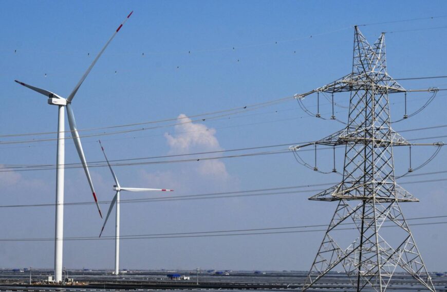 Una torre de transmissió elèctrica i aerogeneradors apareixen a la imatge de la Planta d’Energia Renovable Adani Green a Khavda, a l’estat de Gujarat, a l’Índia, el 15 d’octubre de 2024. (Foto de Punit PARANJPE / AFP)
