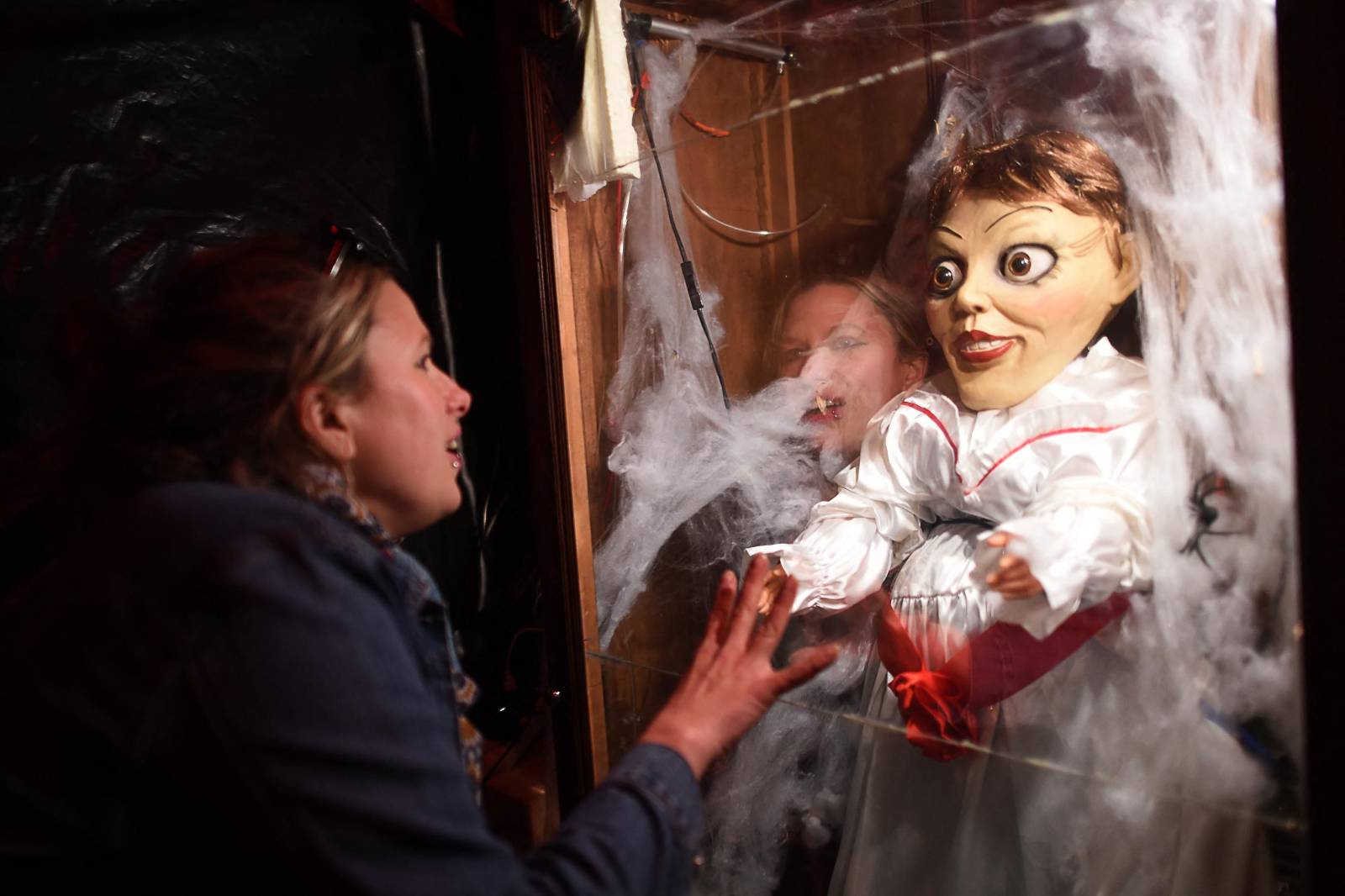 A visitor looks at "Annabelle's Closet", as a doll pops out, in the house of Cedric Le Coz, a horror film enthusiast wich turns his house into a "Haunted House" for Halloween in Le Mans, northwestern France on October 29, 2019. Dismembered dolls crying tears of blood, disturbing noises and objects that get in motion on their own. Fan of horror and Halloween movies, Cedric Le Coz transformed for the third year, his house of Le Mans into a "Haunted House", open to the public. (Photo by JEAN-FRANCOIS MONIER / AFP)