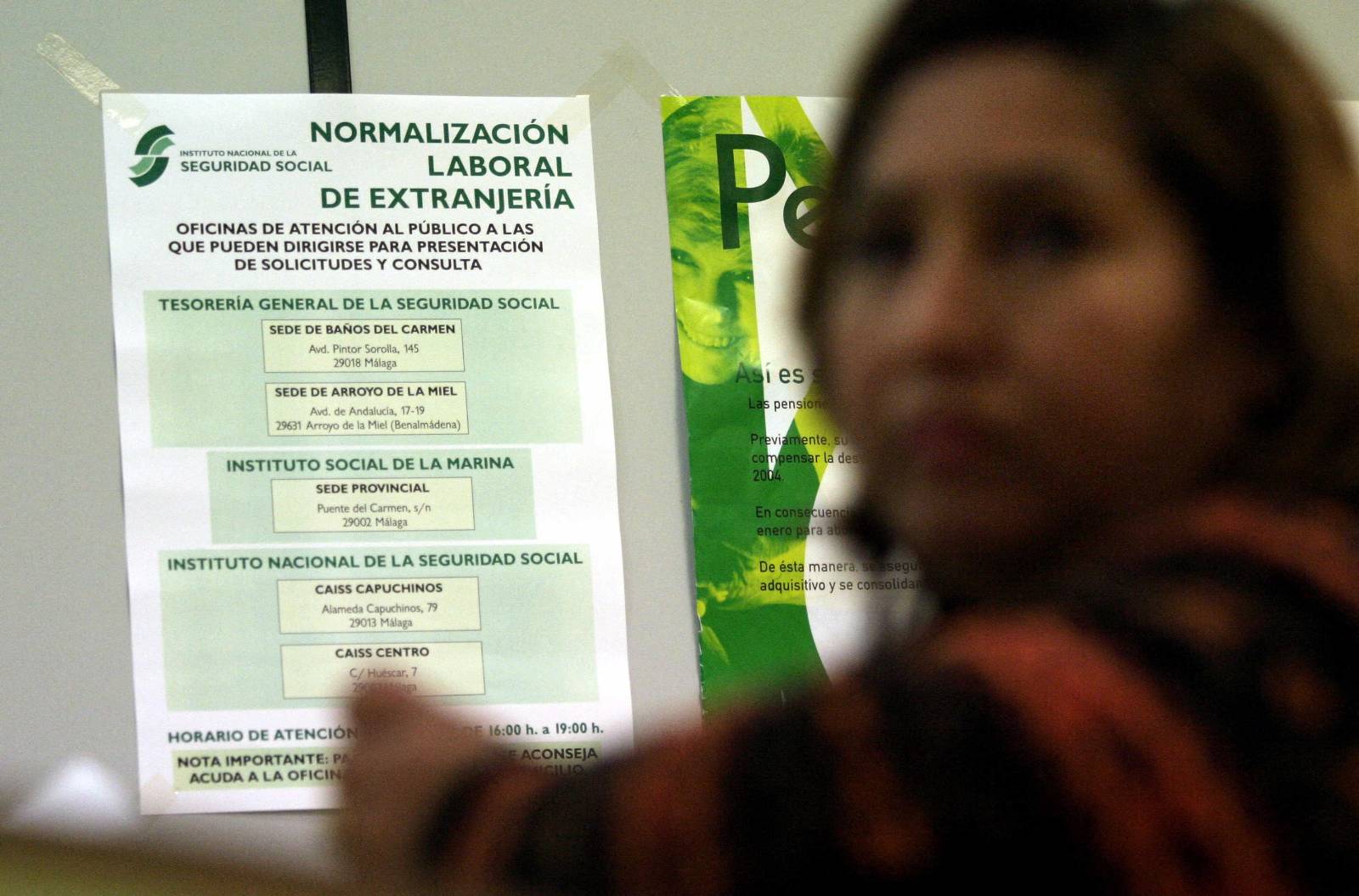 A woman takes a number to wait in line in a Social Security office during the first day of the legalization programme for illegal immigrants in Malaga, 07 February 2004. Spain on Monday launched a major drive to grant legal status to an estimated half a million illegal immigrants already working in the country, but critics say the most vulnerable will not benefit from the scheme. AFP PHOTO/ JOSÉ LUIS ROCA. (Photo by JOSE LUIS ROCA / AFP)