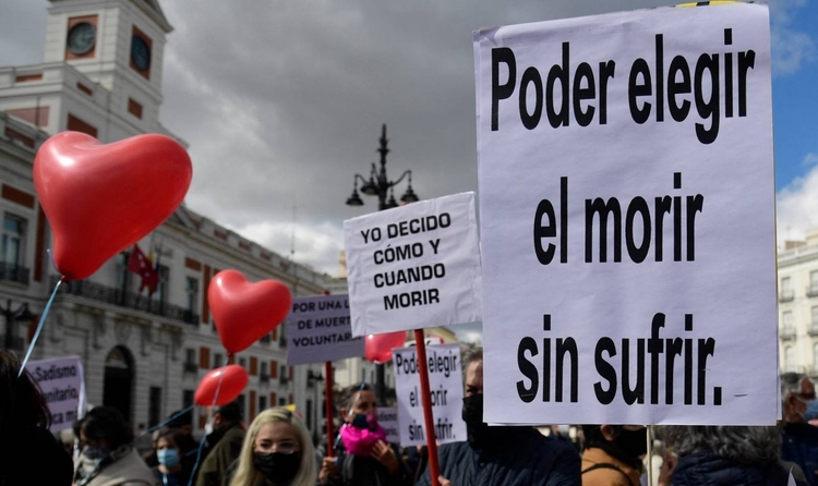People hold placards reading "To choose to die without suffering" and "I decide when and how to die" during a demonstration in support of a law legalising euthanasia in Madrid on March 18, 2021 as Parliament gives final approval to bill decriminalising euthanasia and physician-assisted suicide. The bill, set to get final approval in parliament, will allow someone suffering from a "serious or incurable disease" to receive medical assistance to die. (Photo by JAVIER SORIANO / AFP)