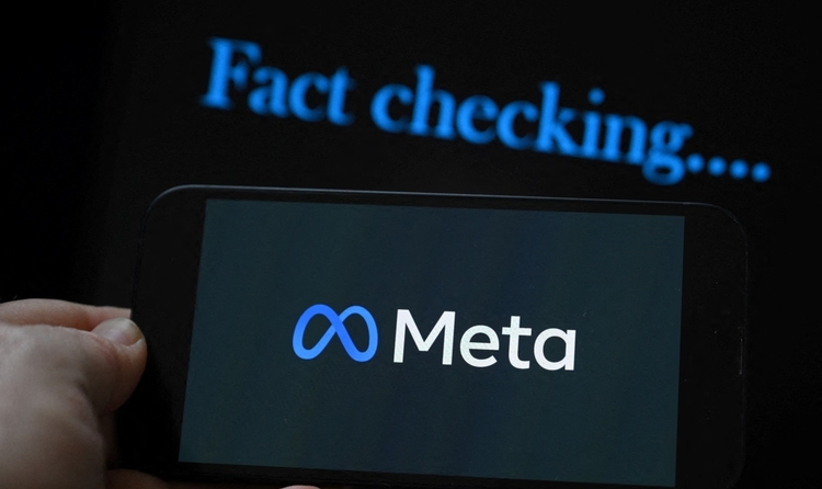 This photo illustration created on January 8, 2025, in Brussels, shows the media giant Meta's logo displayed on a smartphone and screen displaying the words "fact checking". Social media giant Meta on January 7, 2025, slashed its content moderation policies, including ending its US fact-checking program, in a major shift that conforms with the priorities of incoming president Donald Trump. (Photo by Nicolas TUCAT / AFP)