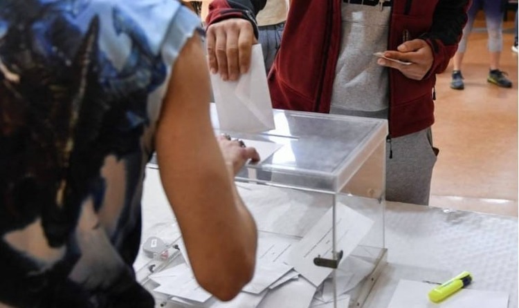 Una persona que va a votar introdueix el sobre a l'urna. Photo by ANDER GILLENEA / AFP