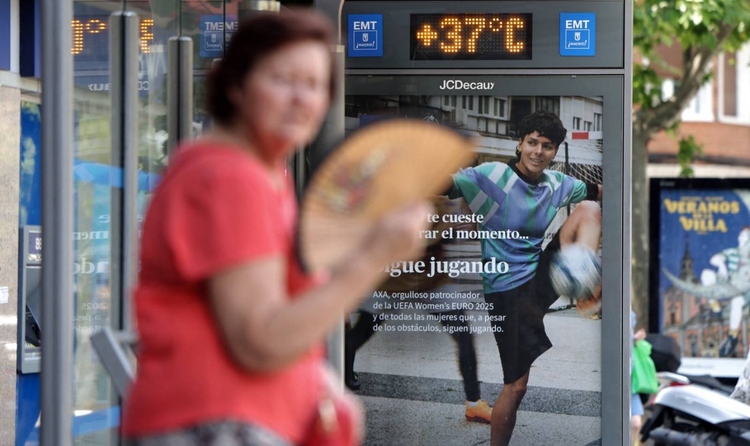 Una dona es refresca amb un ventilador en una parada d'autobús que mostra una temperatura de 37 graus Celsius durant una onada de calor a Madrid, l'1 de juliol de 2025. Espanya va tenir el juny més calorós registrat el mes passat, amb una temperatura mitjana de 23,6 graus Celsius (74,5 graus Fahrenheit), segons ha informat avui el servei meteorològic nacional Aemet. (Foto de Thomas COEX / AFP)